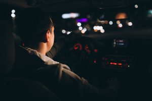 young-man-driving-his-car-night-time